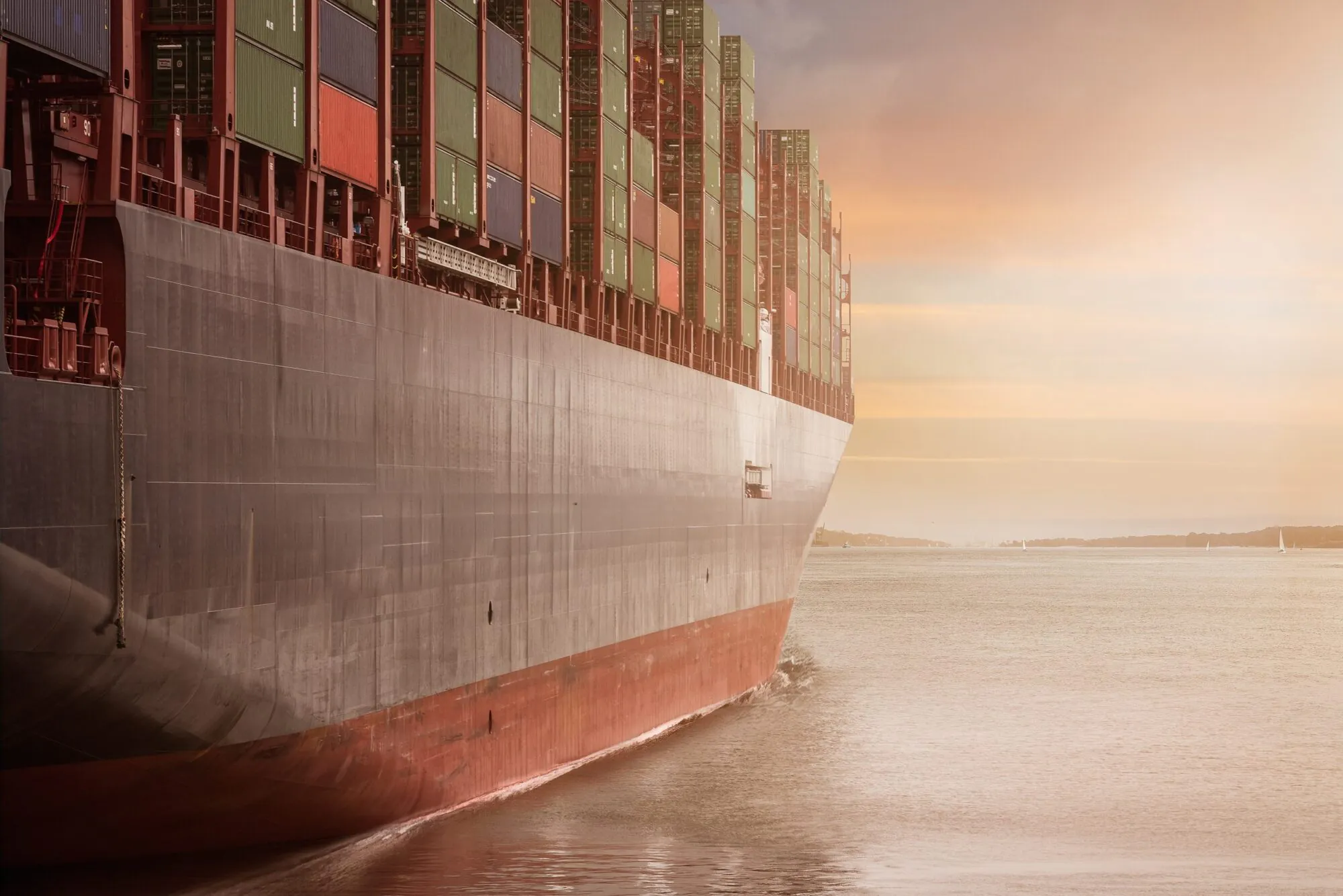 Titelbild für Blogartikel Containerschiff fährt Richtung Sonnenunergang
